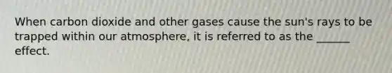 When carbon dioxide and other gases cause the sun's rays to be trapped within our atmosphere, it is referred to as the ______ effect.