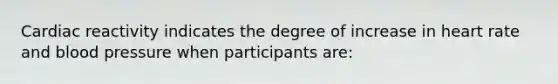 Cardiac reactivity indicates the degree of increase in heart rate and blood pressure when participants are: