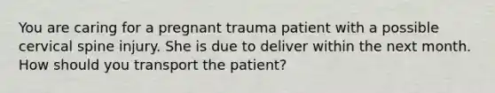 You are caring for a pregnant trauma patient with a possible cervical spine injury. She is due to deliver within the next month. How should you transport the​ patient?