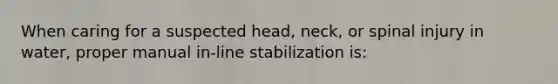 When caring for a suspected head, neck, or spinal injury in water, proper manual in-line stabilization is: