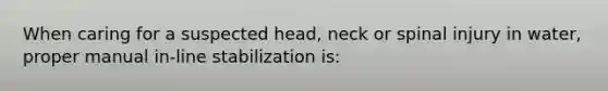 When caring for a suspected head, neck or spinal injury in water, proper manual in-line stabilization is: