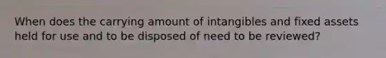 When does the carrying amount of intangibles and fixed assets held for use and to be disposed of need to be reviewed?