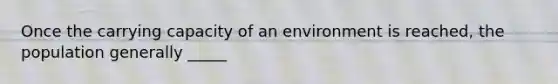 Once the carrying capacity of an environment is reached, the population generally _____