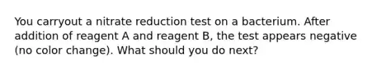 You carryout a nitrate reduction test on a bacterium. After addition of reagent A and reagent B, the test appears negative (no color change). What should you do next?