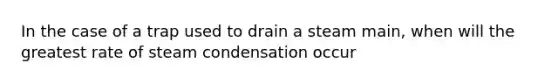 In the case of a trap used to drain a steam main, when will the greatest rate of steam condensation occur