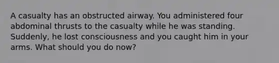 A casualty has an obstructed airway. You administered four abdominal thrusts to the casualty while he was standing. Suddenly, he lost consciousness and you caught him in your arms. What should you do now?