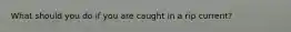 What should you do if you are caught in a rip current?