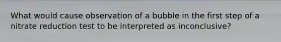 What would cause observation of a bubble in the first step of a nitrate reduction test to be interpreted as inconclusive?