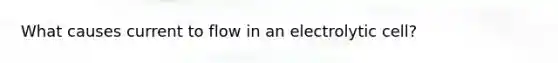 What causes current to flow in an electrolytic cell?