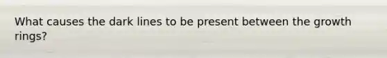 What causes the dark lines to be present between the growth rings?