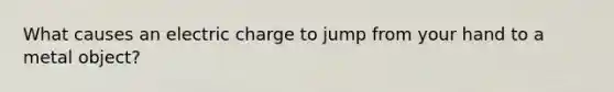 What causes an electric charge to jump from your hand to a metal object?