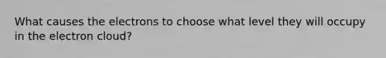 What causes the electrons to choose what level they will occupy in the electron cloud?