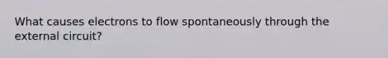 What causes electrons to flow spontaneously through the external circuit?