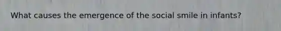 What causes the emergence of the social smile in infants?