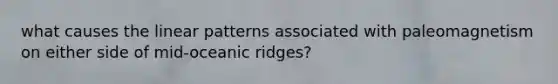 what causes the linear patterns associated with paleomagnetism on either side of mid-oceanic ridges?