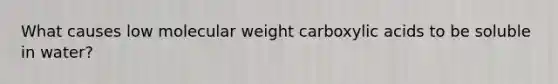 What causes low molecular weight carboxylic acids to be soluble in water?