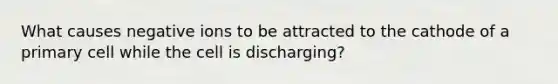 What causes negative ions to be attracted to the cathode of a primary cell while the cell is discharging?