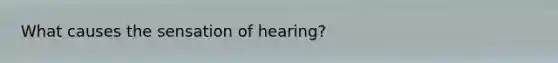 What causes the sensation of hearing?