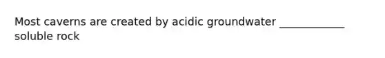 Most caverns are created by acidic groundwater ____________ soluble rock