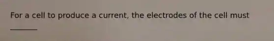 For a cell to produce a current, the electrodes of the cell must _______