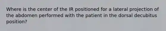 Where is the center of the IR positioned for a lateral projection of the abdomen performed with the patient in the dorsal decubitus position?