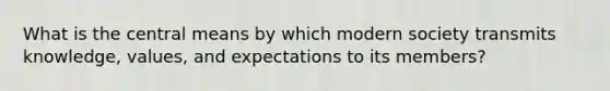 What is the central means by which modern society transmits knowledge, values, and expectations to its members?