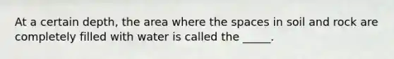 At a certain depth, the area where the spaces in soil and rock are completely filled with water is called the _____.