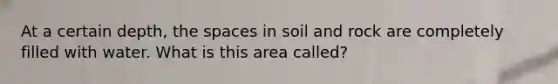 At a certain depth, the spaces in soil and rock are completely filled with water. What is this area called?