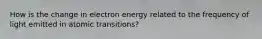 How is the change in electron energy related to the frequency of light emitted in atomic transitions?