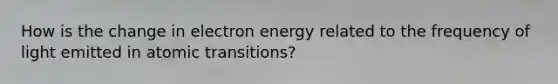 How is the change in electron energy related to the frequency of light emitted in atomic transitions?