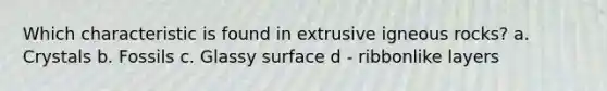 Which characteristic is found in extrusive igneous rocks? a. Crystals b. Fossils c. Glassy surface d - ribbonlike layers