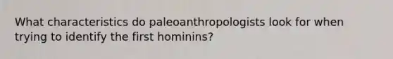 What characteristics do paleoanthropologists look for when trying to identify the first hominins?