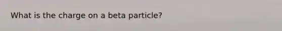 What is the charge on a beta particle?