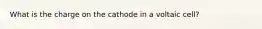 What is the charge on the cathode in a voltaic cell?