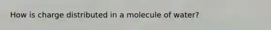 How is charge distributed in a molecule of water?