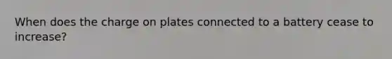 When does the charge on plates connected to a battery cease to increase?