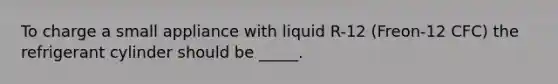 To charge a small appliance with liquid R-12 (Freon-12 CFC) the refrigerant cylinder should be _____.