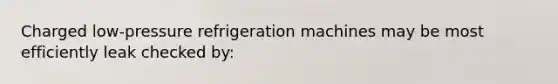 Charged low-pressure refrigeration machines may be most efficiently leak checked by: