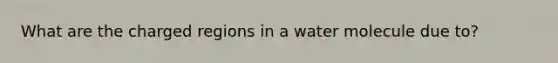 What are the charged regions in a water molecule due to?