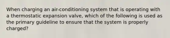 When charging an air-conditioning system that is operating with a thermostatic expansion valve, which of the following is used as the primary guideline to ensure that the system is properly charged?