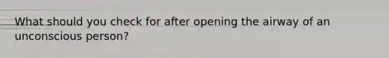 What should you check for after opening the airway of an unconscious person?