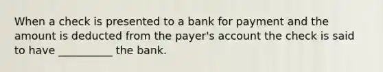 When a check is presented to a bank for payment and the amount is deducted from the payer's account the check is said to have __________ the bank.