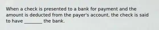 When a check is presented to a bank for payment and the amount is deducted from the payer's account, the check is said to have ________ the bank.