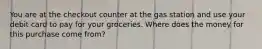 You are at the checkout counter at the gas station and use your debit card to pay for your groceries. Where does the money for this purchase come from?