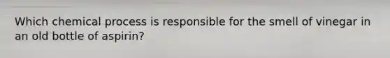 Which chemical process is responsible for the smell of vinegar in an old bottle of aspirin?