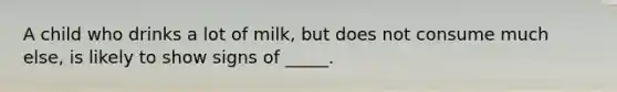 A child who drinks a lot of milk, but does not consume much else, is likely to show signs of _____.​