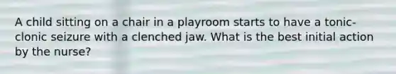 A child sitting on a chair in a playroom starts to have a tonic-clonic seizure with a clenched jaw. What is the best initial action by the nurse?