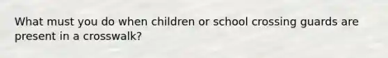 What must you do when children or school crossing guards are present in a crosswalk?