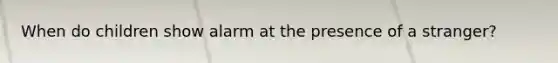 When do children show alarm at the presence of a stranger?