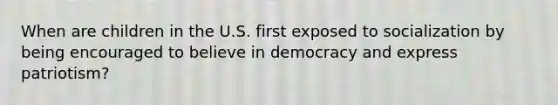 When are children in the U.S. first exposed to socialization by being encouraged to believe in democracy and express patriotism?